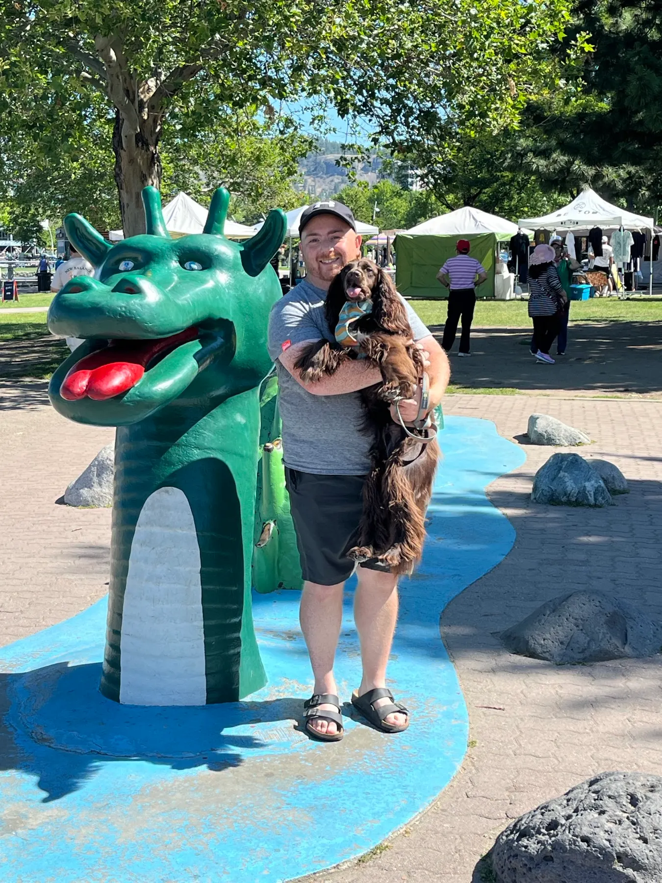 Tilly and Shaun beside the green Ogopogo figure on Kelowna's waterfront