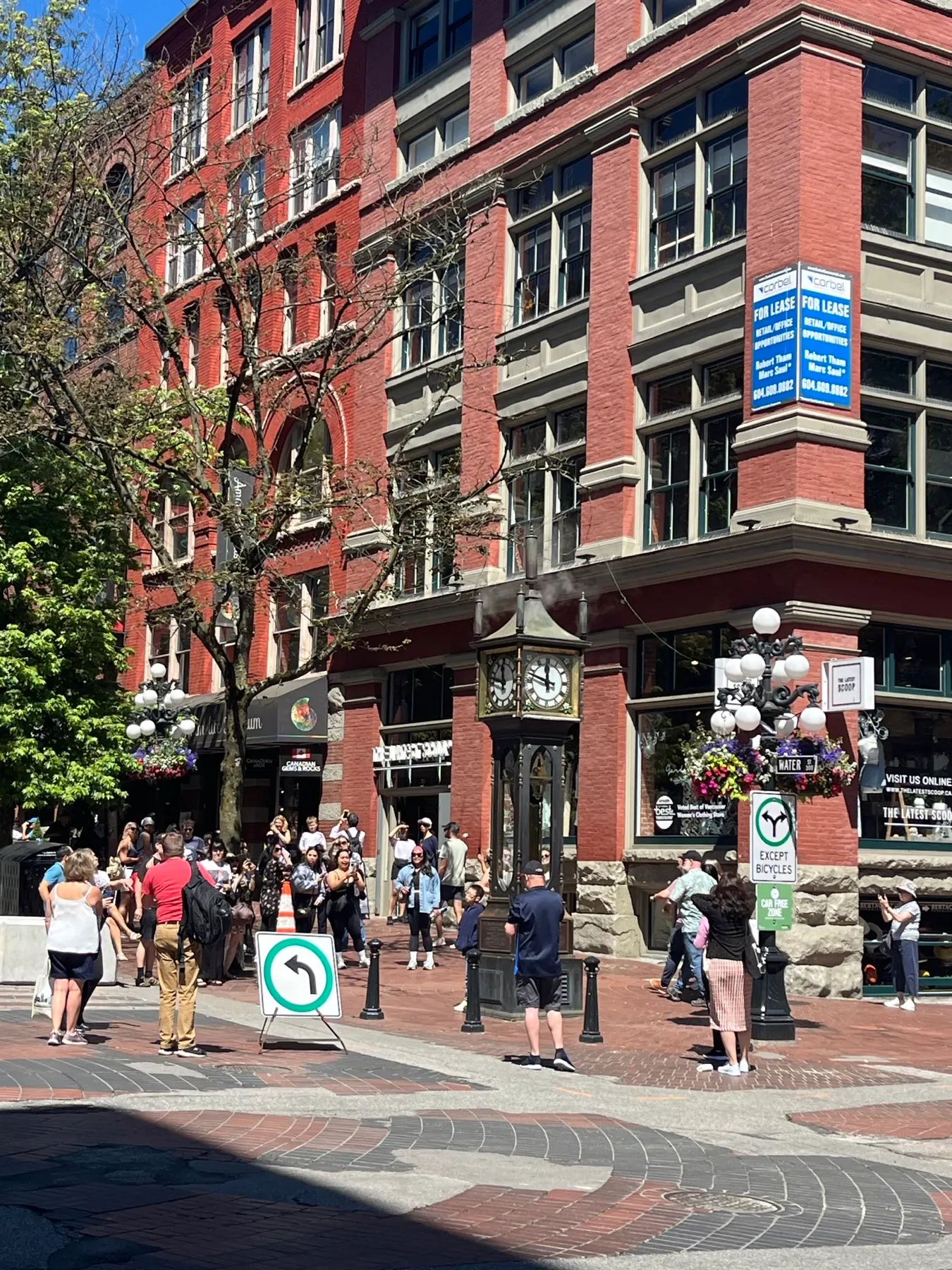 The Gastown Steam Clock surrounded by visitors and brick buildings
