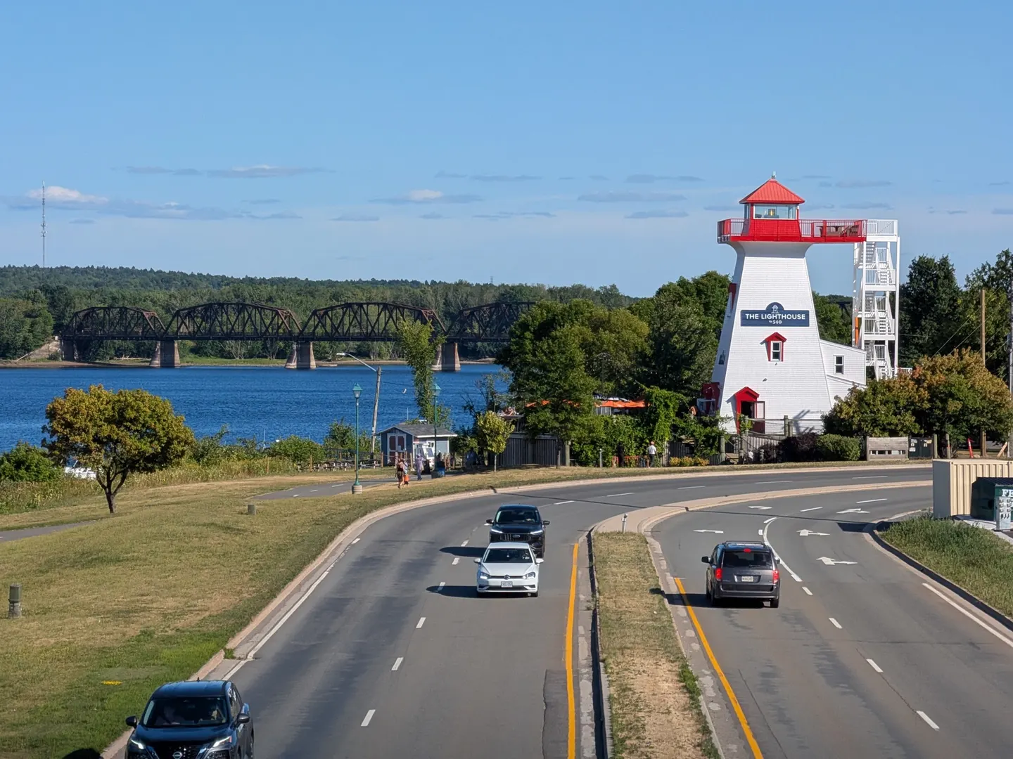 The Fredericton lighthouse on the riverfront with a bridge in the background