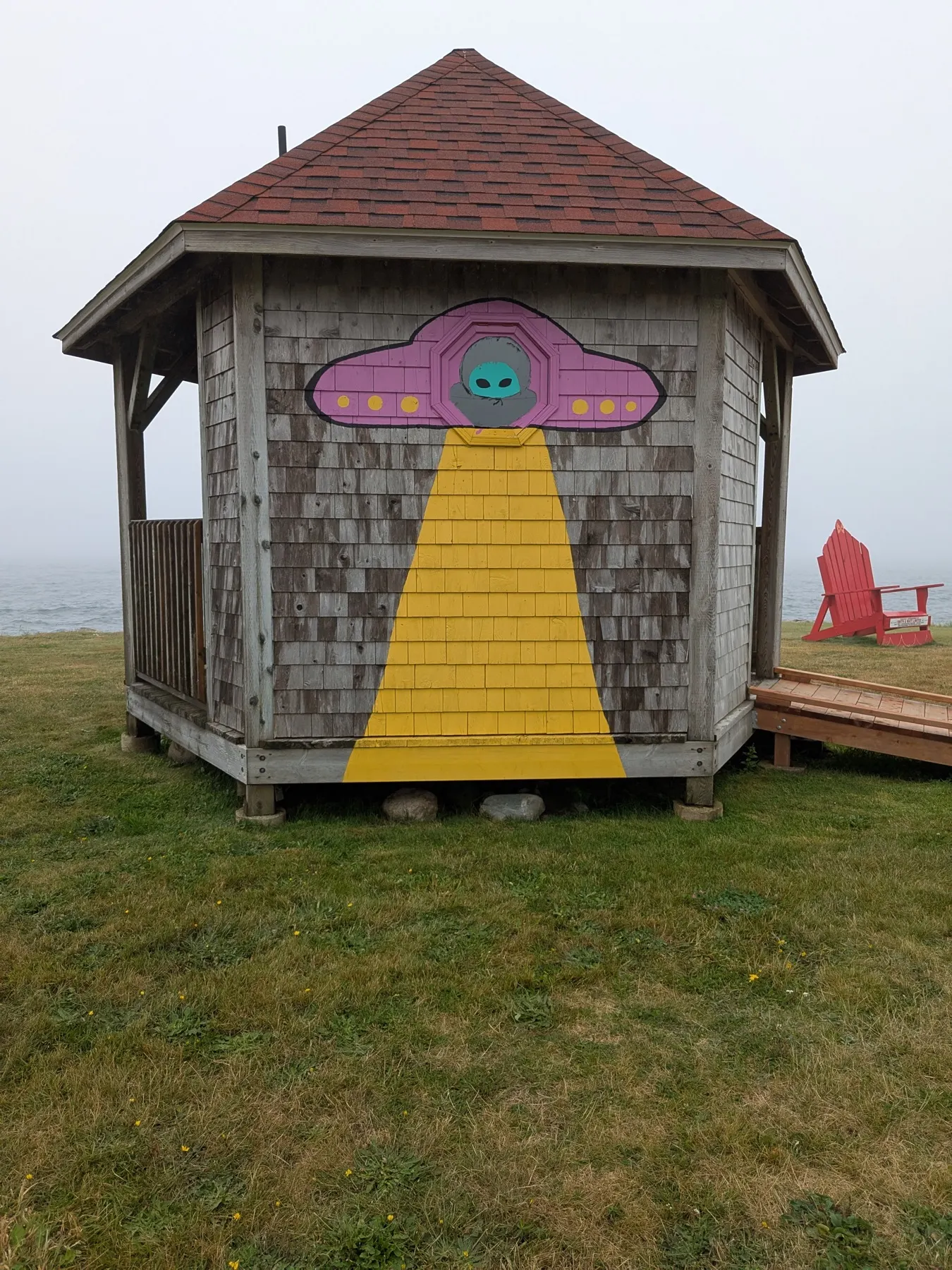 A visitor kiosk painted with a UFO beaming up an alien at Shag Harbour