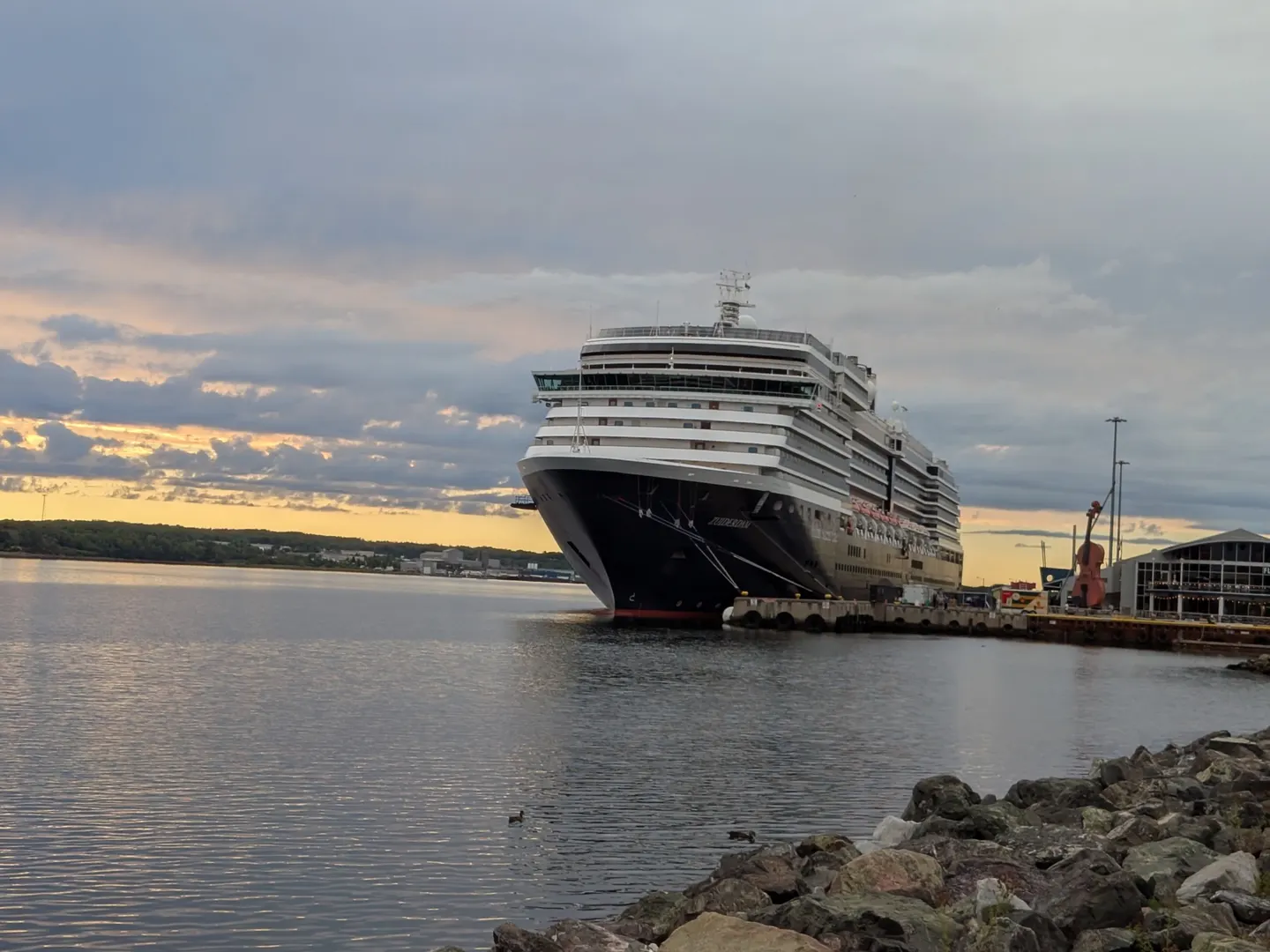 A cruise ship docked in Sydney harbour at sunset